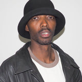 Man wearing a black hat and leather jacket against a white background