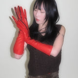 Person wearing red gloves against a plain background
