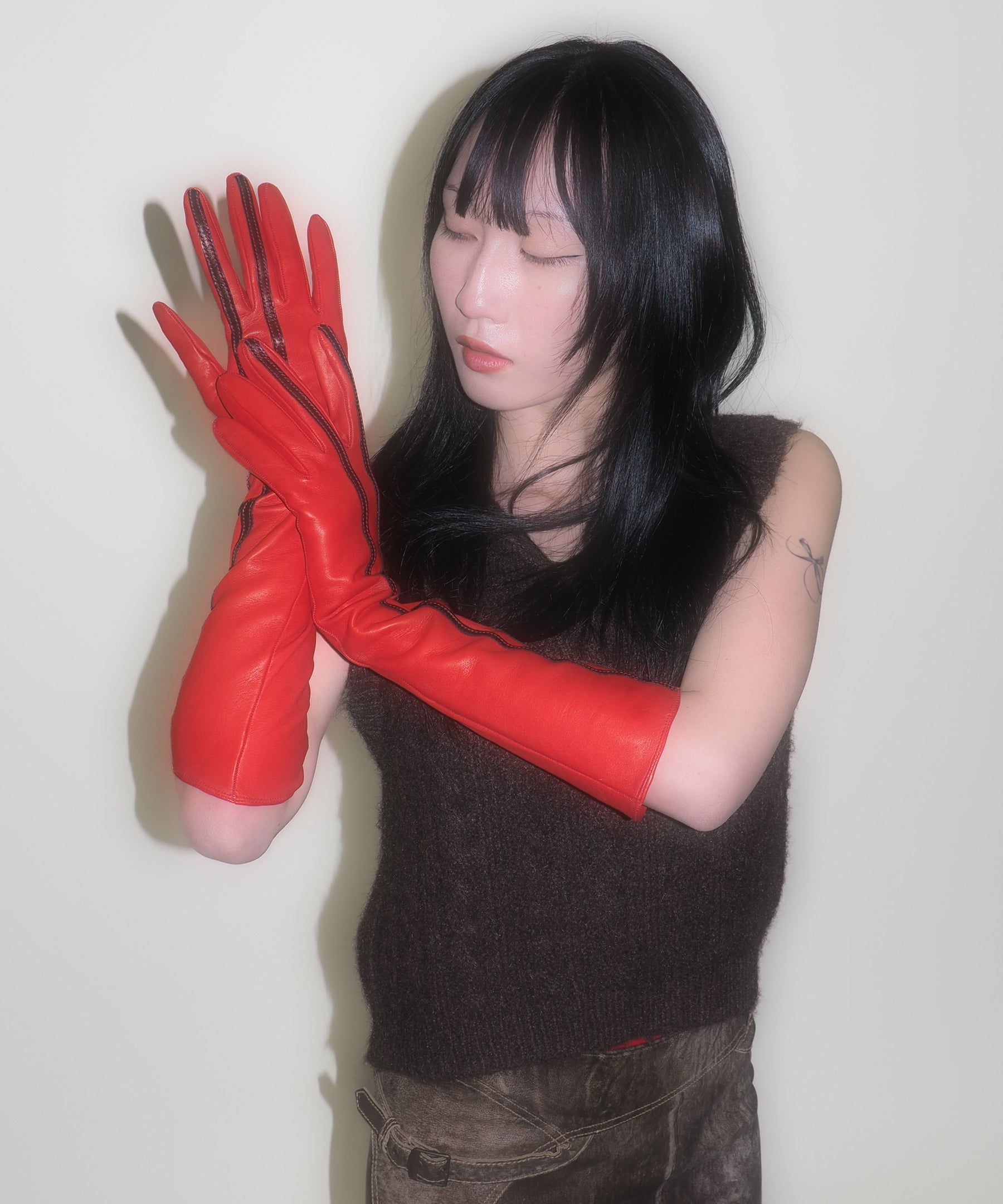 Person wearing red gloves against a plain background