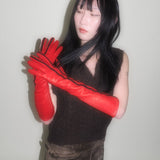 Person wearing red gloves with a plain background