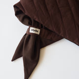 A close-up of a folded dark brown scarf with a small white brand tag reading 'clyde' attached near the corner, set against a plain white background.