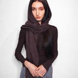 A model wearing a dark brown hooded long-sleeve top and a matching brown scarf, paired with a blue and white checkered skirt, against a plain light gray background.